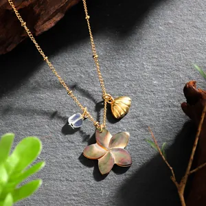 Detail view of Hawaiian necklace with iridescent shell flower and golden shell charms