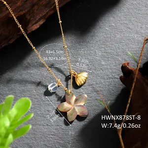 Detailed close-up of shell flower and golden conch charms on a beaded hawaiian necklace