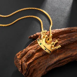 Luxurious 18k gold plated crown pendant necklace with green crystals on wood background