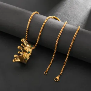 Detail of 18k gold crown pendant with green crystals and gold box chain necklace