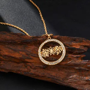 Collar monstera dorado con cristales blancos sobre un fondo de madera rústica