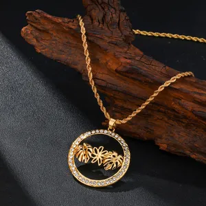 Collar con colgante de hoja de monstera dorada y cristale sobre madera rústica