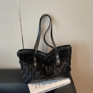 Chic black faux fur tote bag with leather straps on a minimalist indoor display