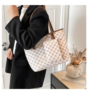 Detail of a beige tote bag with brown diamond pattern and matching small pouch