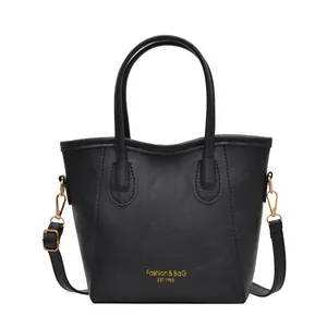 Sac seau élégant en cuir texturé noir avec lettrage doré et bandoulière réglable chic