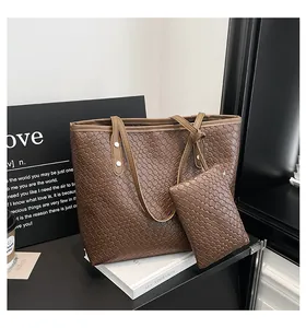 Gedetailleerde macro van donkerbruine gevlochten shopper met bijpassende kleine portemonnee