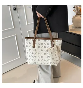 Détail du grand sac cabas crème à motifs floraux avec sa petite pochette assortie