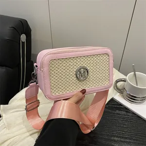 Rosafarbene Box-Umhängetasche mit beige gewebtem Panel und silbernem M-Logo handgehalten