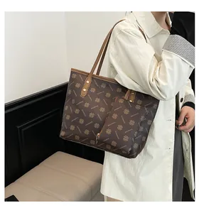 Vue détaillée du sac cabas marron foncé avec motif trèfle et pochette amovible
