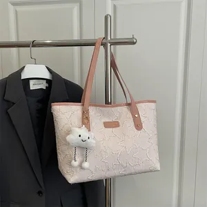 Pink tote bag with star pattern and cloud charm on a metallic stand in a bright room