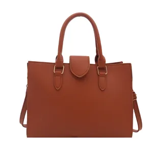 Brown lychee leather tote bag with double round handles and gold hardware details