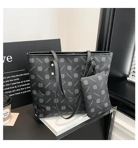 Détail du sac cabas noir imprimé et sa pochette assortie dans un décor urbain chic