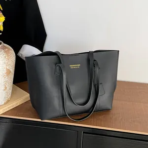 Minimalist black faux leather large tote bag with gold logo for daily commute usage