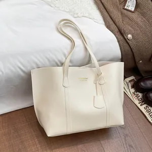 Fashionable beige large-capacity tote bag with dual shoulder straps on a cozy lifestyle background