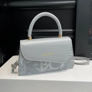 Bolso cuadrado de cuero azul grisáceo con estampado de grafiti y detalles dorados finos
