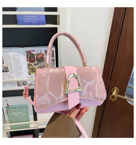 Gros plan du sac à main carré rose avec boucle dorée et textures abstraites