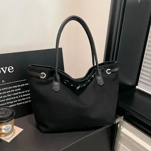 Grote minimalistische zwarte tote bag van suède met zilveren metalen ringetjes