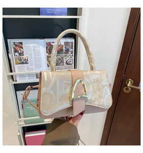 Détail du sac à main beige avec imprimés blancs et boucle en métal doré en fer à cheval