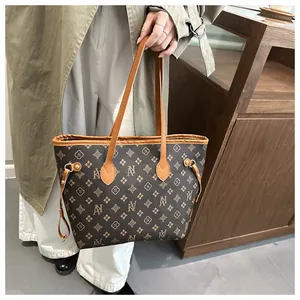 Detail of elegant large tote bag with luxury monogram print and brown leather handles