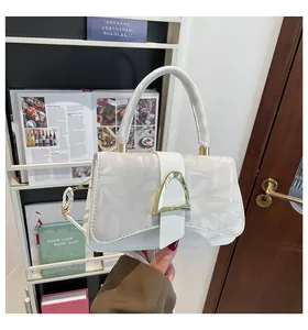 Vue détaillée du sac à main en cuir gaufré blanc avec boucle dorée en forme de D élégante