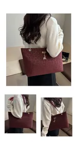 Détail du sac cabas bordeaux à imprimé léopard avec pendentif doré et chaîne