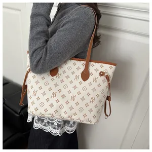 Side view of cream tote bag with brown trim and floral monogram pattern on model