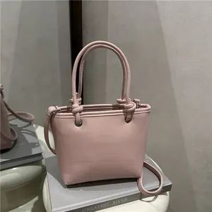 Pink matte leather minimalist tote bag with knot handle for shoulder or crossbody use
