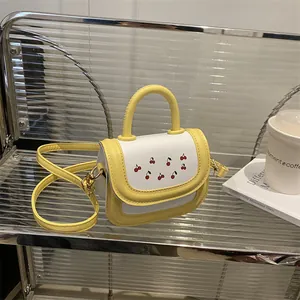 Mini crossbody bag with yellow and white contrast colors and cherry print on metal shelf