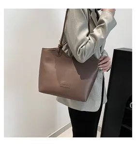 Detail of knot shoulder strap and fashion label on brown leather tote bag