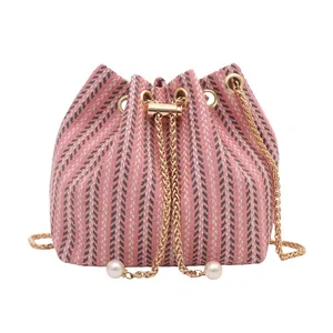 Bolso cubo de punto rosa con diseño de espiga, cadena dorada y detalles de perlas finas