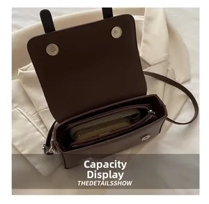 Détail de l'intérieur du sac en cuir marron montrant la capacité pour téléphone