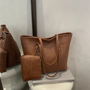 Minimalist caramel brown leather tote bag with small zipper pouch for women's daily commute