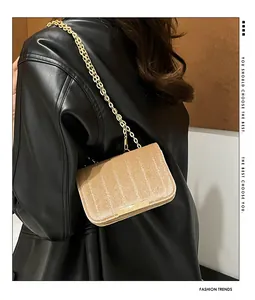 Detailed view of light brown velvet crossbody bag with gold chain and vertical quilting