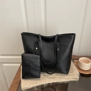 Minimalist large black tote bag set with textured leather and gold hardware accents