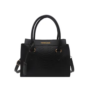 Minimalist black faux leather handbag with snake pattern texture and gold metal accents