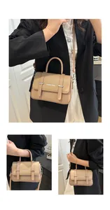 Detalle de bolso de cuero beige y marrón con decoración de cinturón y hebillas plata