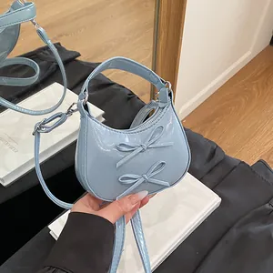 Mini sac à main bleu clair en cuir verni avec nœuds élégants et finition brillante