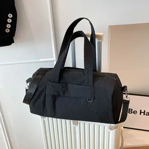 Sac bowling noir en nylon fixé sur une poignée de bagage pour voyage et sport