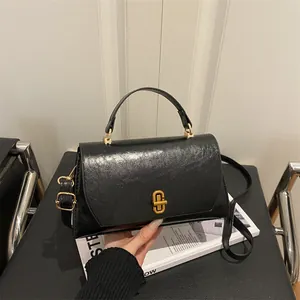 Vintage black oil-wax leather handbag with gold metal twist-lock and top handle