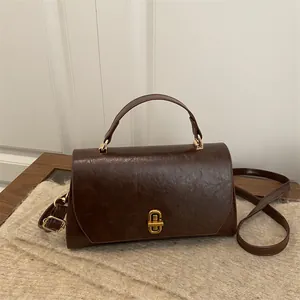 Vintage dark brown crossbody bag with gold oval twist lock and adjustable strap