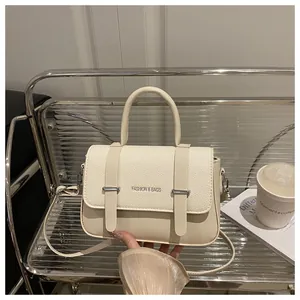 Bolso bandolera de cuero blanco crema con detalle de cinturón y textura combinada