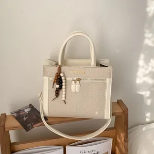 Sac bandoulière beige texturé avec poignée en similicuir et breloque en perles de bois