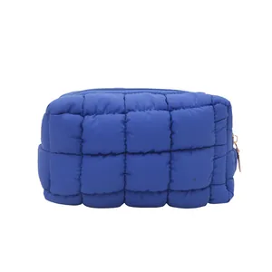 Navy blue quilted nylon makeup bag with puffy square padding and gold metal zipper