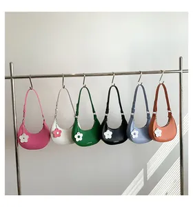 Detailed row of various colorful hobo bags with flower charms on a display rack