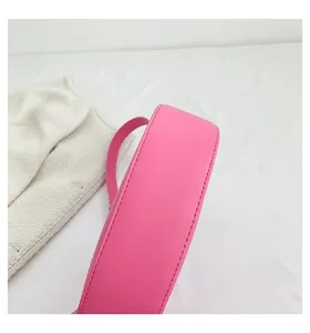 Close-up detail of smooth bright pink leather crescent bag with fine stitching