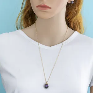 Detail of gold necklace and earring set with deep purple pearls on model