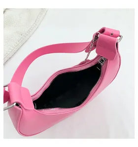 Top view of pink half-moon shoulder bag showing smooth zipper and black interior lining