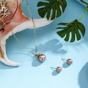 Macro detail of gold necklace and earrings set featuring purple pearls and shell accents