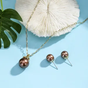 Detailed macro view of chocolate brown pearl necklace set with golden paperclip chain