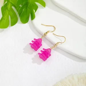 Macro shot of rose pink floral resin drop earrings with elegant gold hook hardware